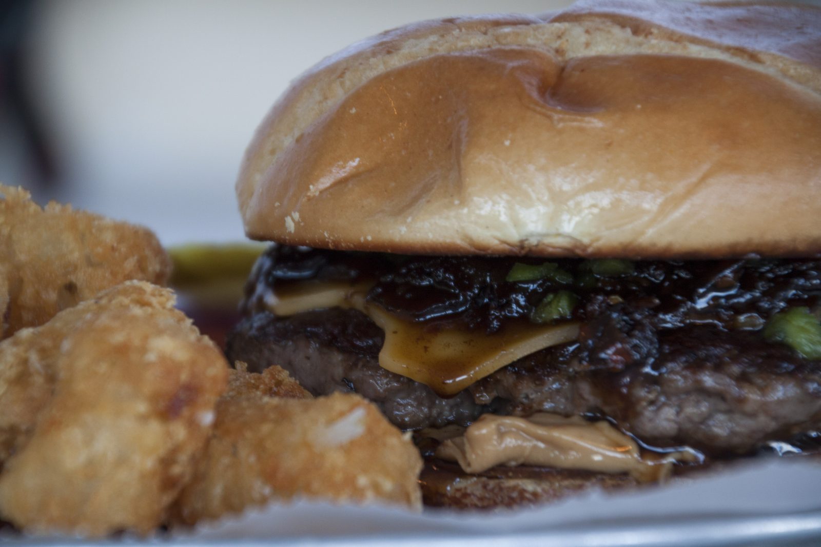 Tiki BBQ burger with melted cheese and crispy tots